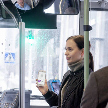 En ung kvinna var sin biljett på en mobiltelefon i en buss.