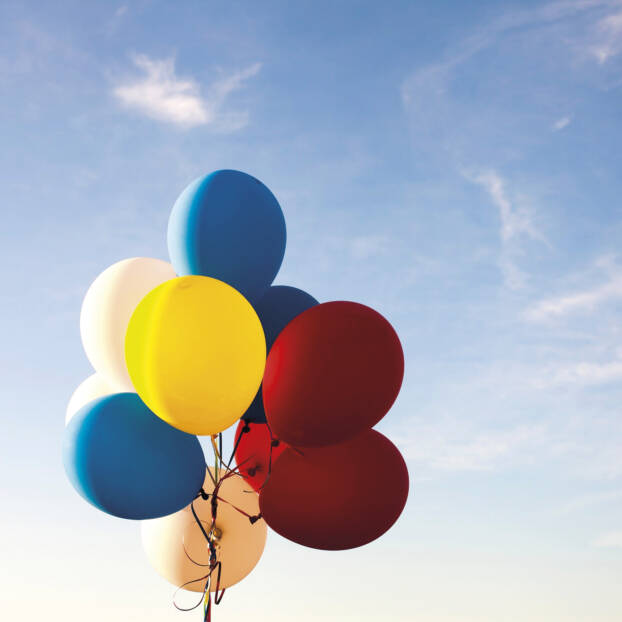Ballonger i olika färger mot en blå himmel.