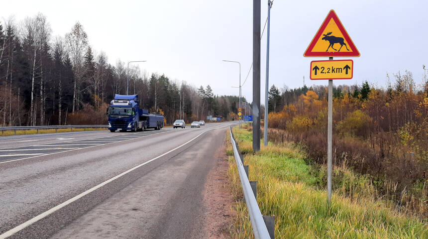 Kuvassa kantatie 51, tiellä rekka ja autoja ja tienreunassa varoitusmerkki hirvistä.